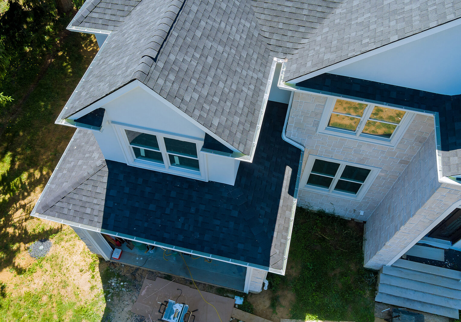 Rooftop in a new home constructed showing asphalt shingles multiple roof lines with aerial view